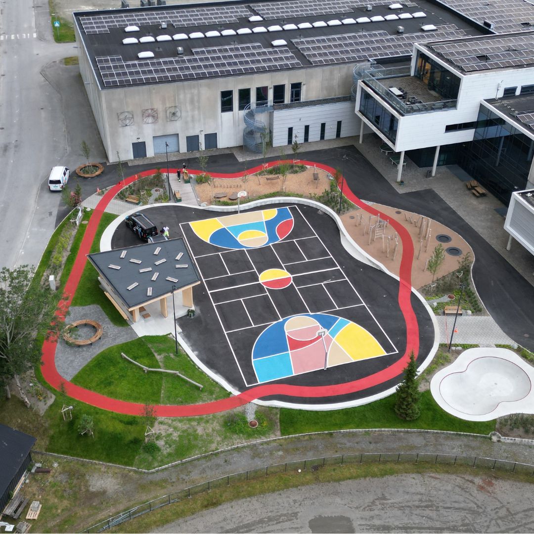 To fagarbeidere i Gulv & Tak-arbeidstøy legger rød overflatebehandling på sykkelfelt langs sjøen